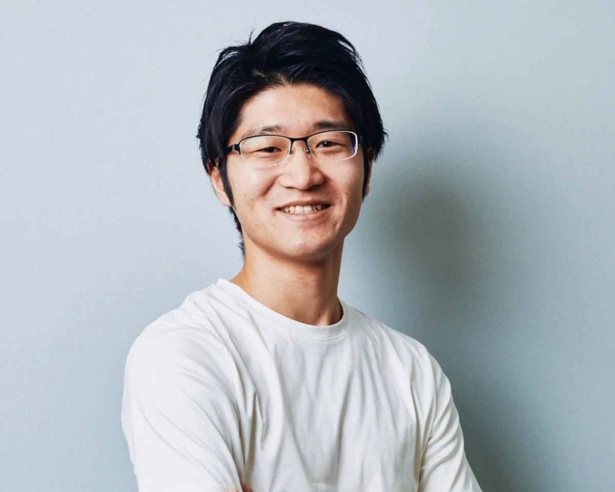 白いTシャツを着てメガネをかけたアジア人男性のポートレート